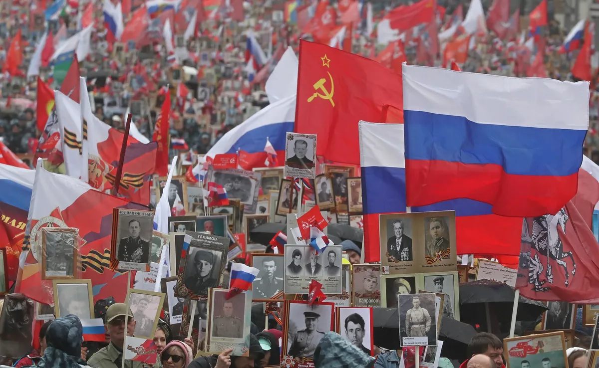 People hold up portraits of their relatives who fought World War II as part of Victory Day celebrations in Moscow’s Red Square, 9 May 2022. Photo: EPA-EFE / MAXIM SHIPENKOV