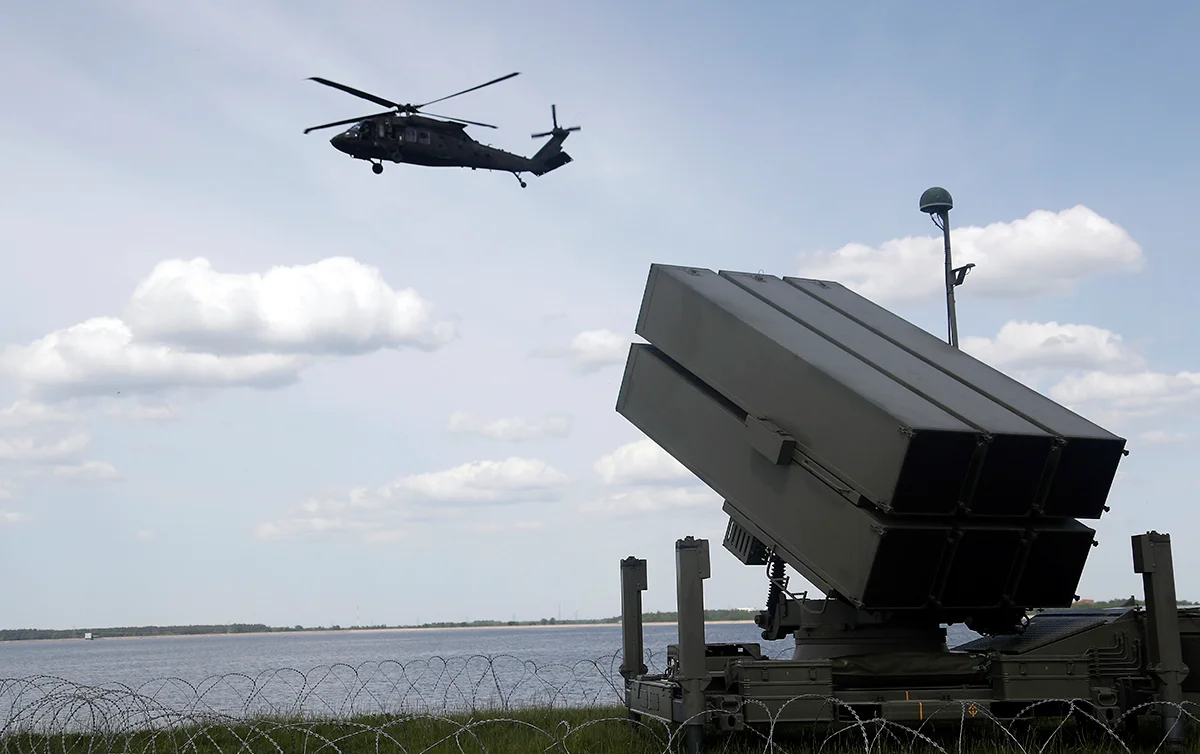 Вертолет Black Hawk армии США и испанский зенитно-ракетный комплекс (NASAMS) на учениях «Латвийский щит 25» на Рижской гидроэлектростанции в Доле, Латвия, 28 мая 2025 года. Фото: Toms Kalnins / EPA