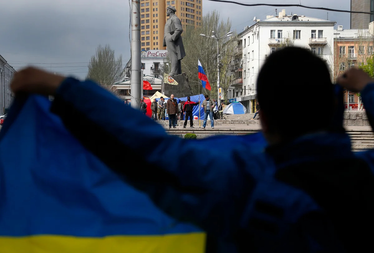Протестующий с украинским флагом напротив пророссийских активистов в Донецке, Украина, 22 апреля 2014 года. Фото: Sergei Grits / AP Photo / Scanpix / LETA