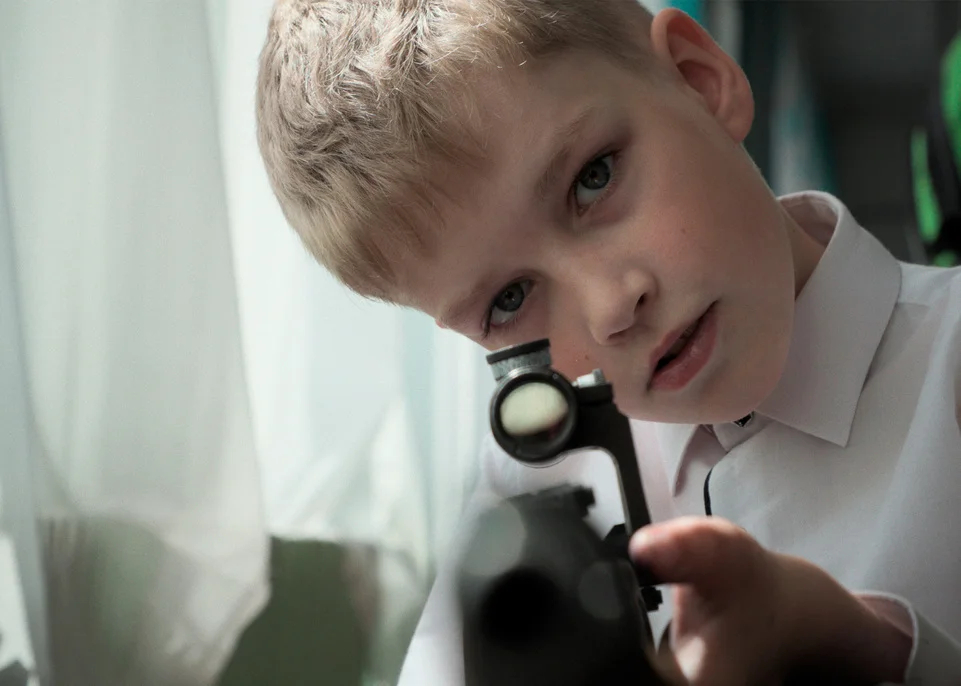 A boy holds a gun in a still from Mr. Nobody Against Putin. Photo: Pink Productions
