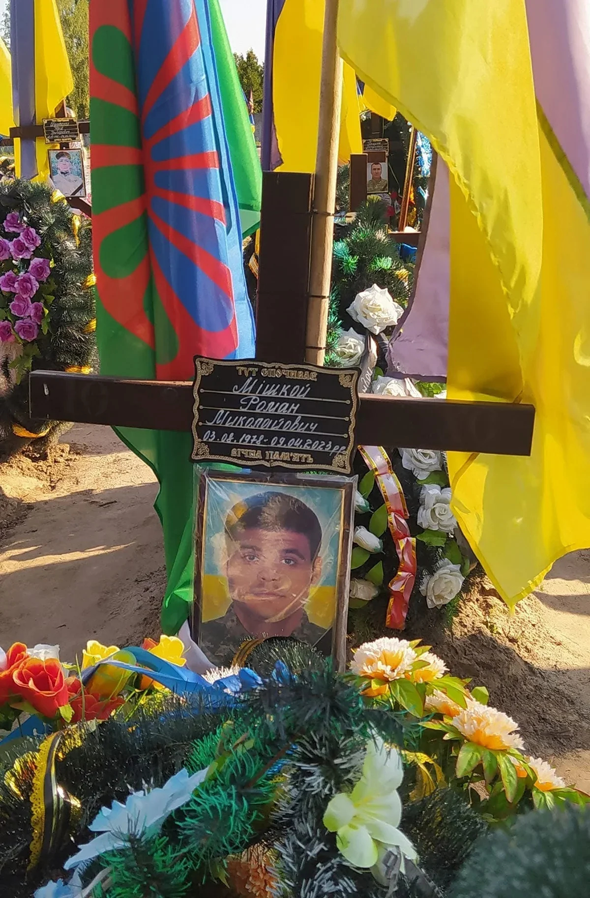 Two flags, Ukrainian and Roma, are placed on the graves of fallen Roma soldiers. Photo: Olga Musafirova