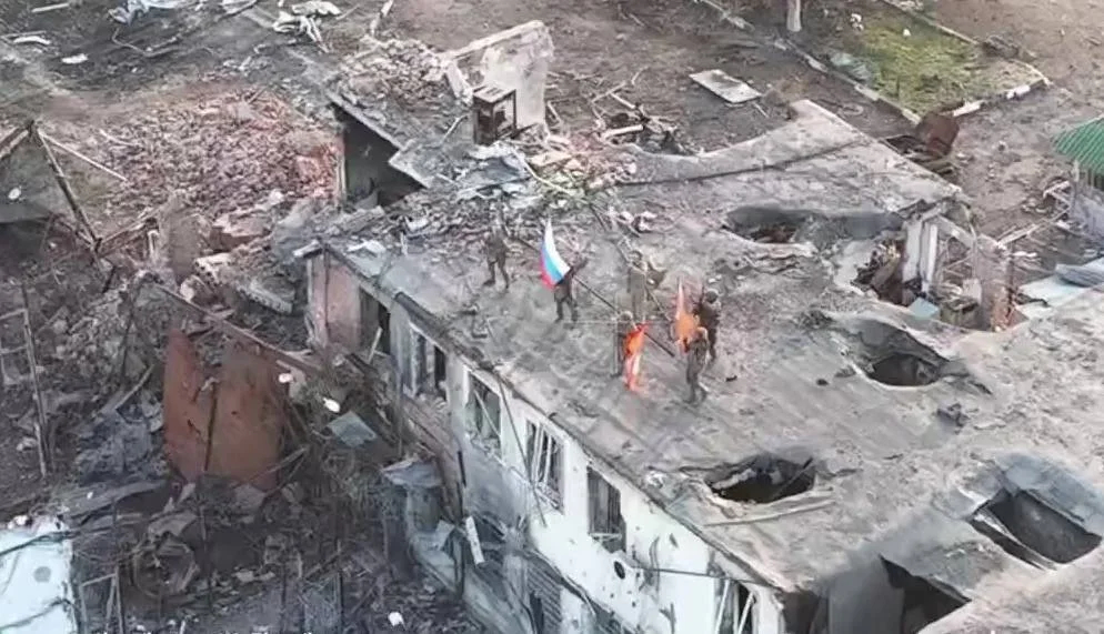 Russian servicemen raise the Russian flag on a building in Malaya Loknya, Kursk region, 9 March 2025. Still from Russian Defence Ministry footage
