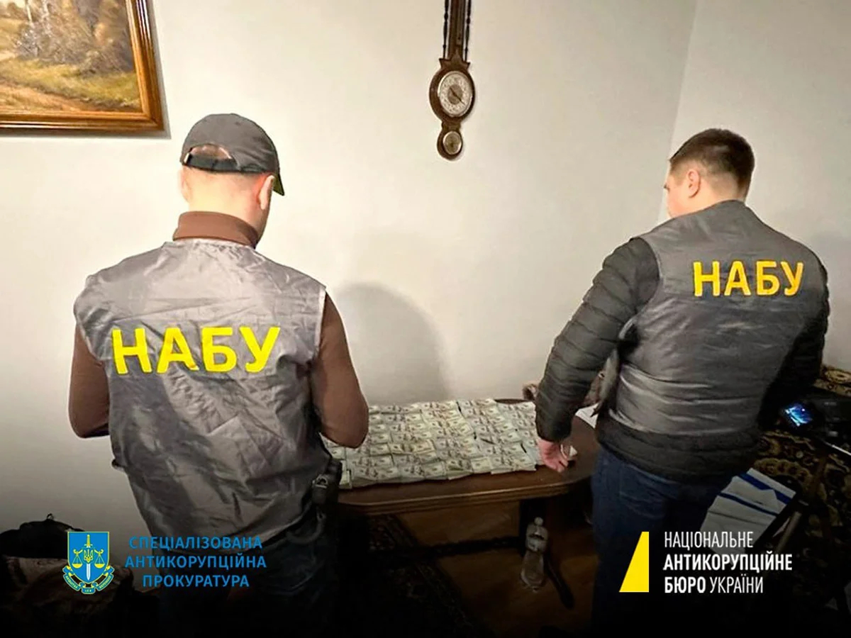 Сотрудники НАБУ рядом с изъятыми деньгами, 23 января 2023 года. Фото: AFP / Scanpix / LETA