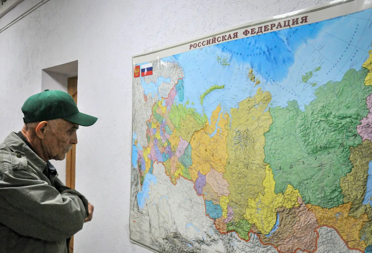 A man examines a map of Russia in an accommodation centre for refugees from Mariupol in Taganrog, in southern Russia’s Rostov region, 22 April 2022. Photo: EPA-EFE / ARKADY BUDNITSKY