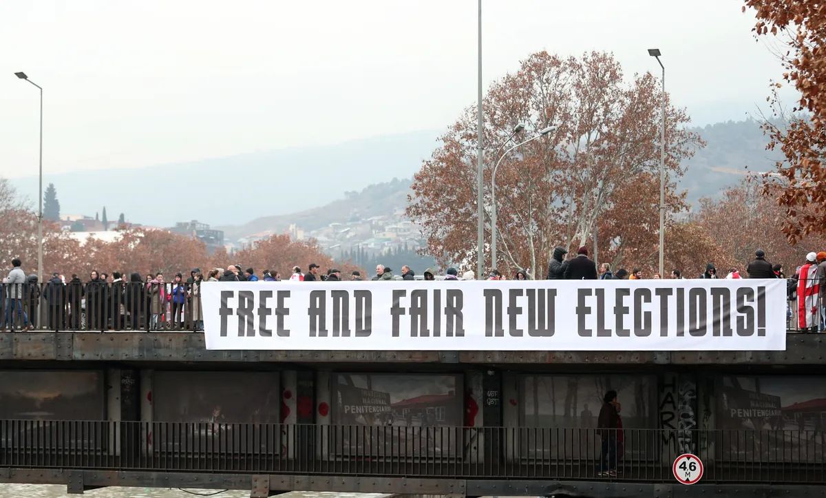 Georgian protesters display a banner during an anti-government rally in Tbilisi, Georgia, 28 December 2024. Photo: EPA-EFE / DAVID MDZINARISHVILI