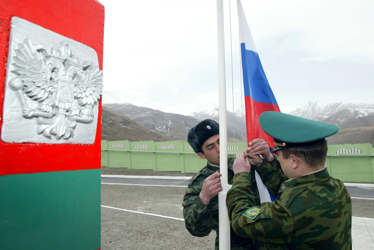 Российские пограничники закрепляют флаг на российско-грузинской границе возле Фиагдона, Северная Осетия, 24 марта 2006 года. Фото: Эдуард Корниенко / Reuters / Scanpix / LETA