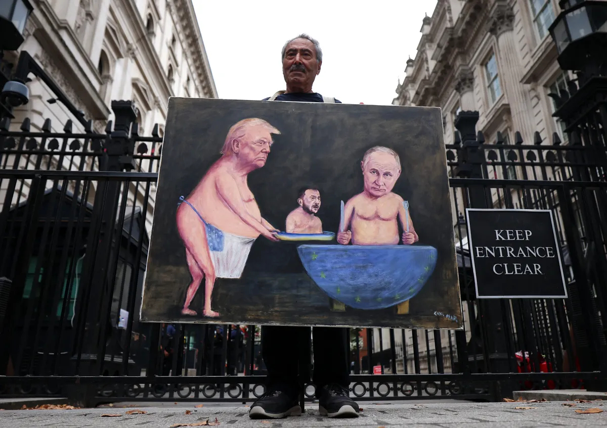 Political satirist Kaya Mar holds his picture of Donald Trump serving Ukrainian President Volodymyr Zelensky up to Putin on a plate outside Downing Street in London, 13 August 2025. Photo: EPA / ANDY RAIN