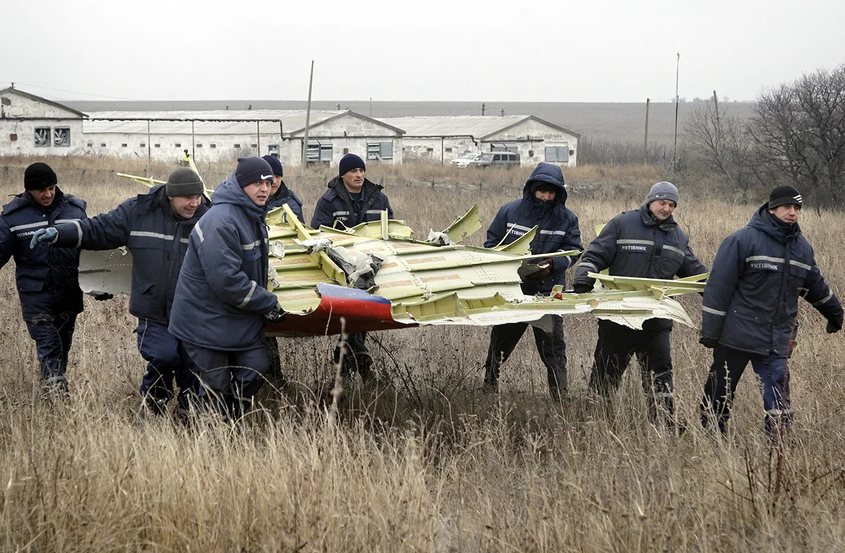Рабочие разбирают части обломков пассажирского самолета MH17 авиакомпании Malaysia Airlines на месте крушения в селе Грабово, Донецк, Украина, 18 ноября 2014 года. Фото: Александр Ермоченко / EPA